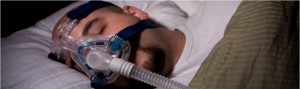Image of sleeping man using a CPAP device to aid breathing.