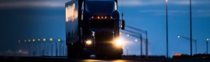 Image of a truck driving at nighttime.
